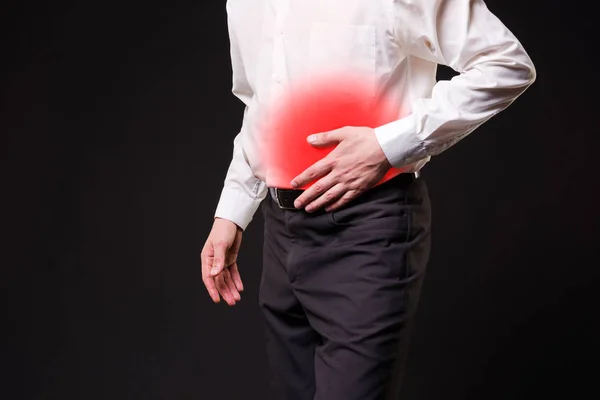 Homem com dor abdominal, dor de estômago em fundo preto — Fotografia de Stock