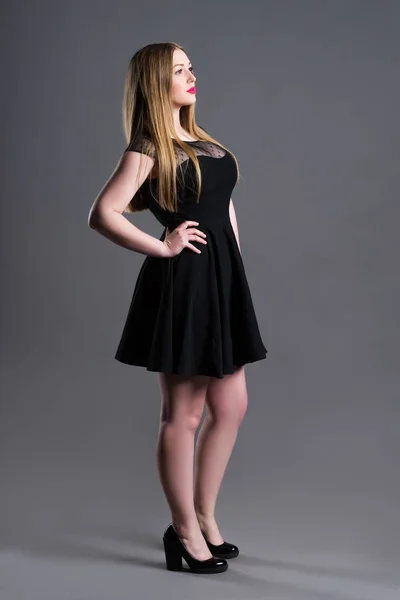 Модель plus size в черном платье, толстая женщина на фоне студии, избыточный вес женского тела — стоковое фото