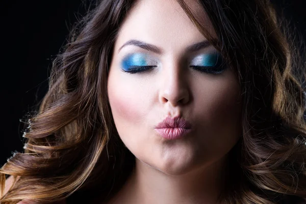 Além de modelo de moda tamanho envia beijo de ar, mulher de beleza com maquiagem profissional e penteado no fundo preto — Fotografia de Stock