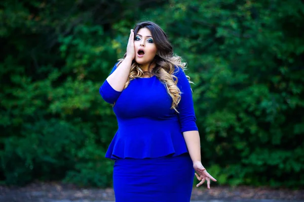 Surpreendido plus size modelo de moda em azul vestido ao ar livre, mulher de beleza com maquiagem profissional e penteado — Fotografia de Stock