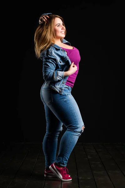 Glücklich plus size-Modell in Blue Jeans, sexy dicke Frau auf schwarzem Studiohintergrund, übergewichtiger weiblicher Körper — Stockfoto