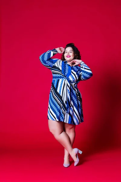 Modelo de talla grande en vestido azul, mujer gorda sobre fondo rojo —  Fotos de Stock