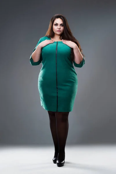 Modelo de talla grande en vestido verde, mujer gorda con pelo largo sobre fondo gris, concepto positivo para el cuerpo — Foto de Stock