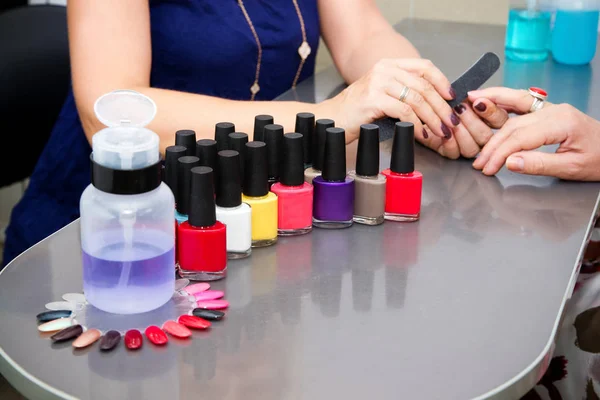 El maestro usa una lima de uñas, haciendo una manicura en el salón de spa —  Fotos de Stock