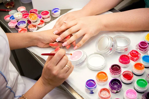 Mestre aplica gel polonês em unhas no salão de manicure — Fotografia de Stock