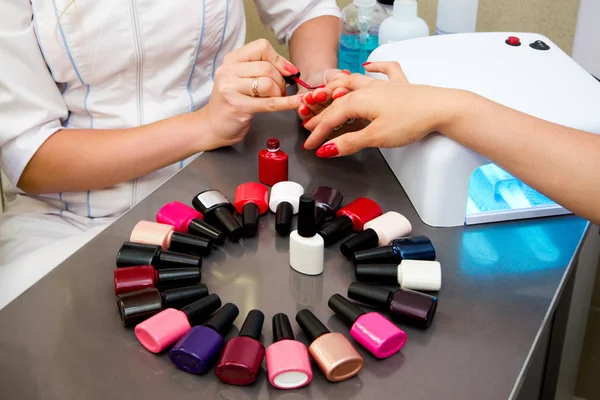 Master applies gel polish on nails in manicure salon — Stock Photo, Image