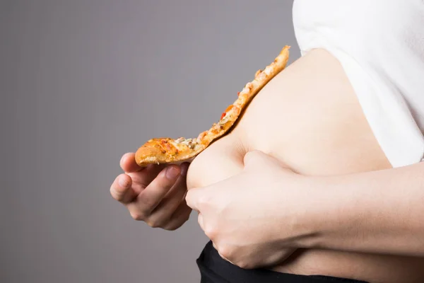 Dicke Frau mit einem Stück Pizza, ungesundes Ernährungskonzept — Stockfoto