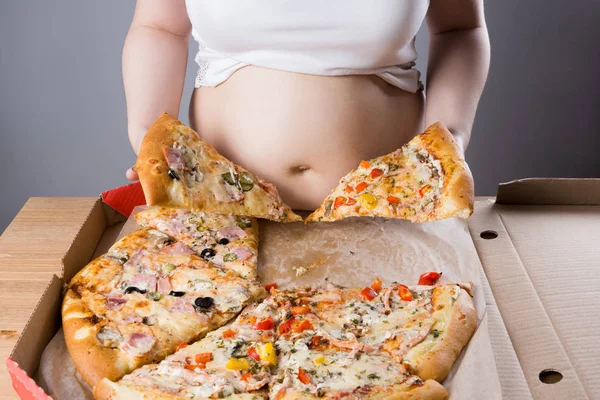 Mujer gorda con un pedazo de pizza, concepto de nutrición poco saludable — Foto de Stock