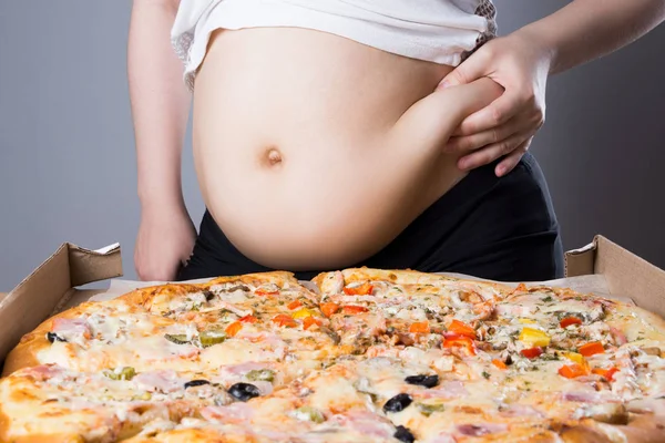 Mujer gorda con un pedazo de pizza, concepto de nutrición poco saludable — Foto de Stock