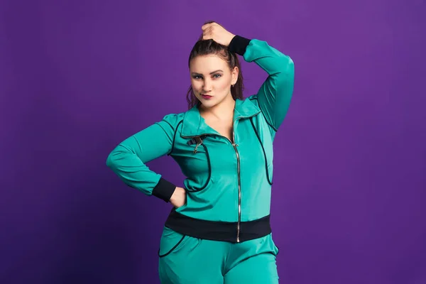 Plus-Size-Modell in Sportbekleidung, dicke Frau auf lila Hintergrund — Stockfoto