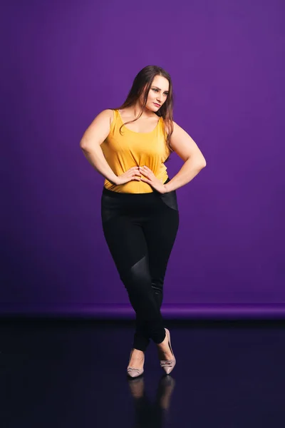 Modelo de moda de talla grande en ropa casual, mujer gorda sobre fondo púrpura — Foto de Stock