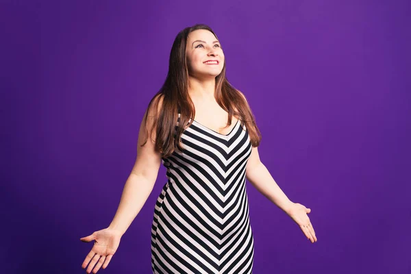 Modelo de tamaño de pize feliz en vestido a rayas, mujer gorda sobre fondo púrpura —  Fotos de Stock