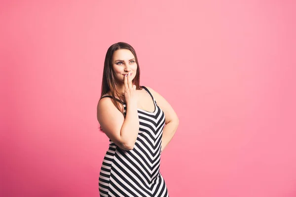 Pensive pize size model in striped dress, fat woman on pink background — Stock Photo, Image