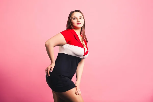 Сексуальная модель plus size в спортивном платье, привлекательная толстая женщина на розовом фоне — стоковое фото