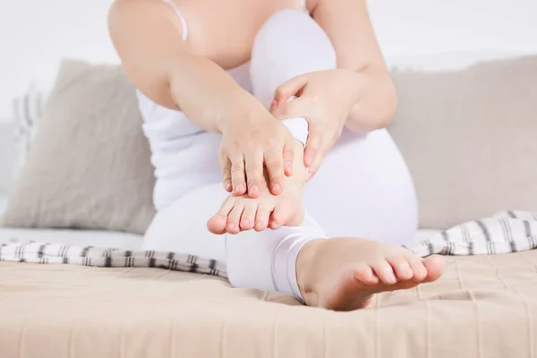 Woman\'s leg hurts, pain in the foot, massage of female feet at home
