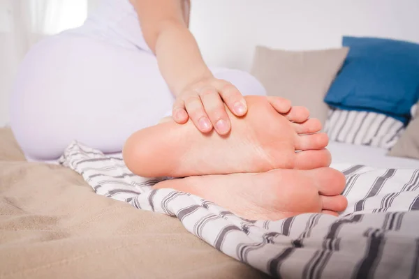 Woman\'s leg hurts, pain in the foot, massage of female feet at home