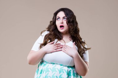 Şaşırdım artı beden modeli, bej arka planda şişman duygusal kadın, vücut pozitifliği