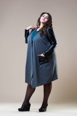 Artı günlük kıyafetlerle manken boy, bej arka planda şişman kadın, vücut pozitifliği, boy boy portresi.