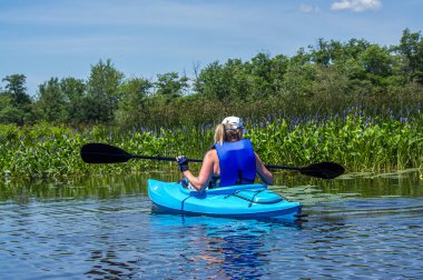 vahşi bir nehir üzerinde bir kayık içinde yalnız kadın