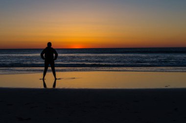 genç kadın okyanus üzerinde güneşin doğuşunu izlemek