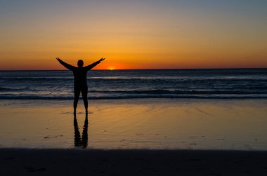 genç kadın okyanus üzerinde güneşin doğuşunu izlemek