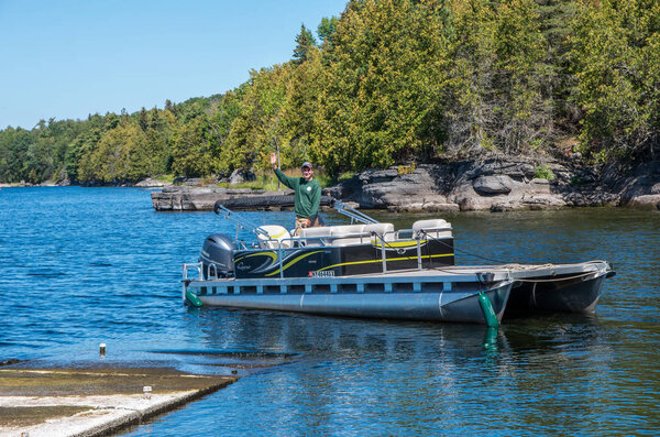 DEC employee waving from a pontoon boat