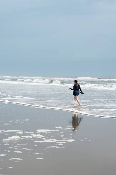 Νεαρή Γυναίκα Που Περπατά Στο Σερφ Κατά Μήκος Της Ακτής — Φωτογραφία Αρχείου