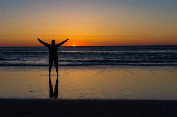 genç kadın okyanus üzerinde güneşin doğuşunu izlemek