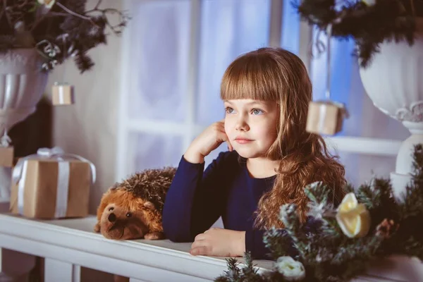 Kleine meisje droomt van een vakantie op de kerst-raamdecoratie — Stockfoto