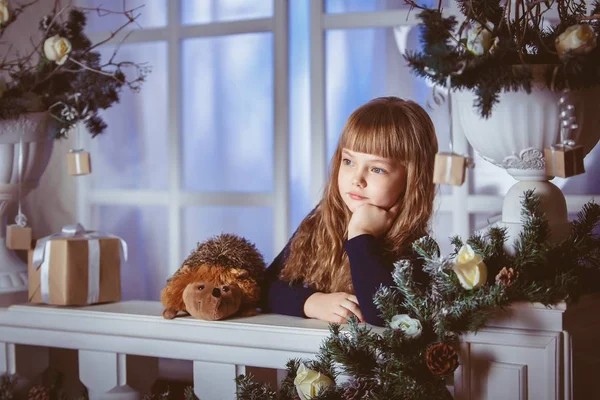 Menina sonha com um feriado na decoração da janela de Natal — Fotografia de Stock