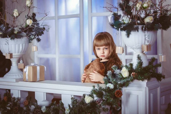 Kleines Mädchen träumt vom Urlaub auf der Weihnachtsfensterdekoration Stockbild