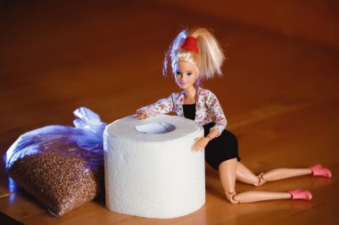 Coronavirus. Tuvalet kağıdı ve karabuğdayla çeşitli pozlarda Barbie bebek..