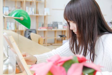 Kahve dükkanında kitap okuyarak bir kız