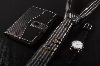 Defter, kravat, kol düğmesi, siyah bir zemin üzerine izle