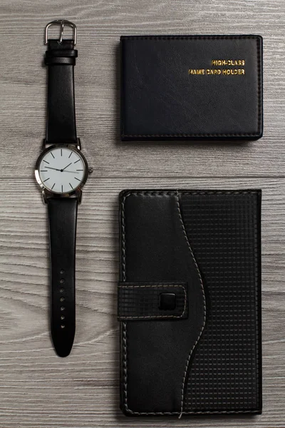 Reloj, cuaderno, titular de la tarjeta de nombre sobre un fondo de madera gris — Foto de Stock