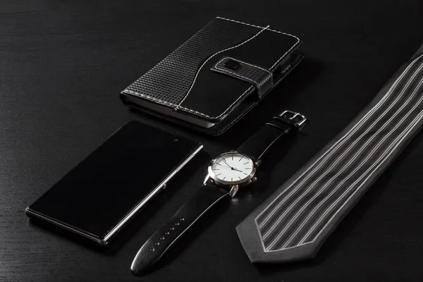 Watch, notebook, eladás telefon, nyakkendő egy fekete háttér — Stock Fotó