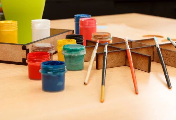 Colorful paints in cups and brushes ready for painting — Stock Photo, Image