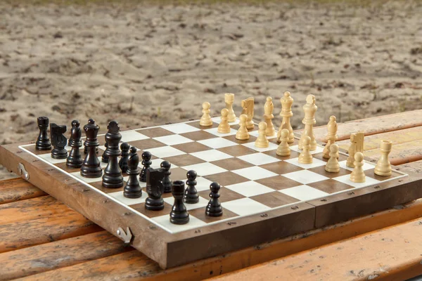 Quadro de xadrez com peças de xadrez em banco de madeira. Ao ar livre xadrez ga — Fotografia de Stock