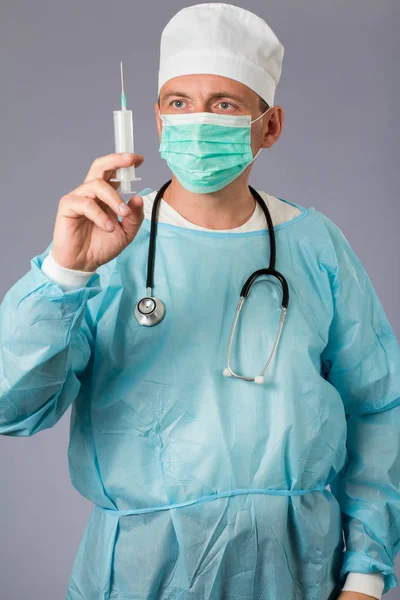 Lekarz medycyny z stetoskop i maskę, trzymając strzykawkę. — Zdjęcie stockowe