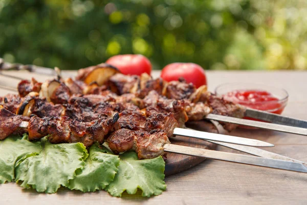 Gegrild varkensvlees op een spies gebakken op de grill en sla bladeren — Stockfoto