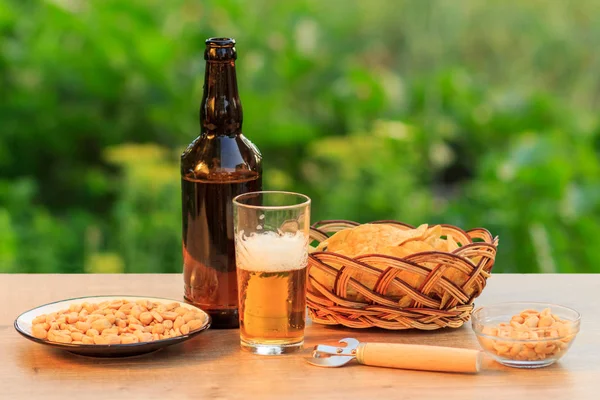 Verre de bière et bouteille de bière sur table en bois avec pomme de terre chi — Photo