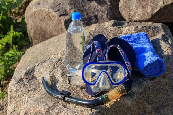 Fles met water, handdoek, slippers, masker om te duiken en snork — Stockfoto