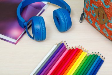 Okul malzemeleri. Okul sırt çantası, kitap, renkli kalemler ve headph