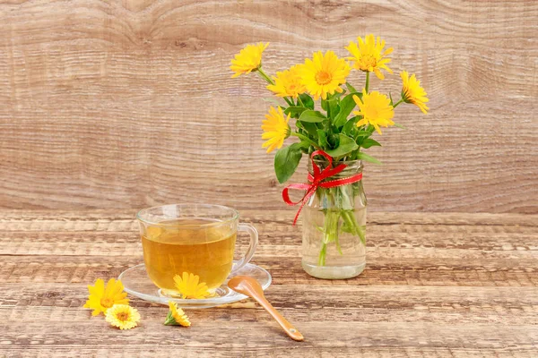 玻璃杯绿茶有花的金盏花和新鲜 bouqu — 图库照片