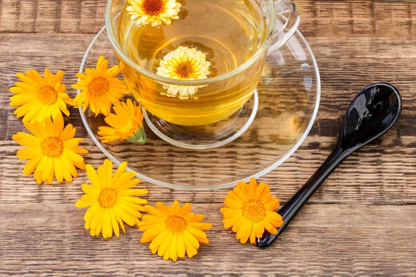 Cam bardak yeşil çay calendula ahşap backg üzerinde çiçekler ile