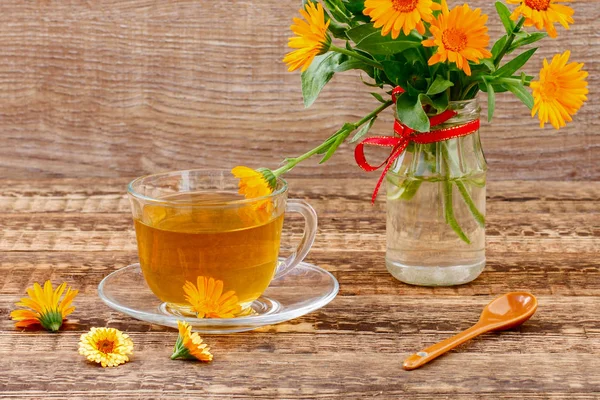 Coupe en verre de thé vert avec des fleurs de calendula et de bouqu frais — Photo