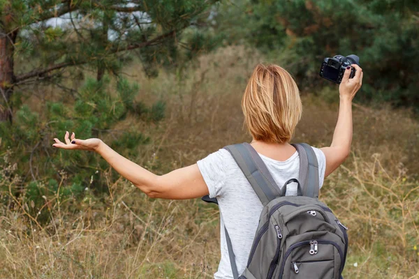 Jovencita caminando en el bosque con cámara digital — Foto de Stock