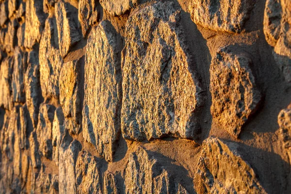 Fragmento de pared de piedra iluminada por el sol. Vista lateral — Foto de Stock