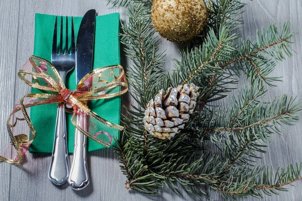 Knife and fork on green napkin with  cone, glittering ball and n — Stock Photo, Image