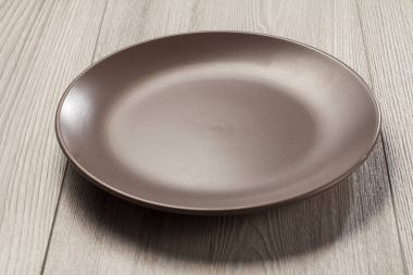 Gri ahşap arka plan üzerinde boş seramik tabak